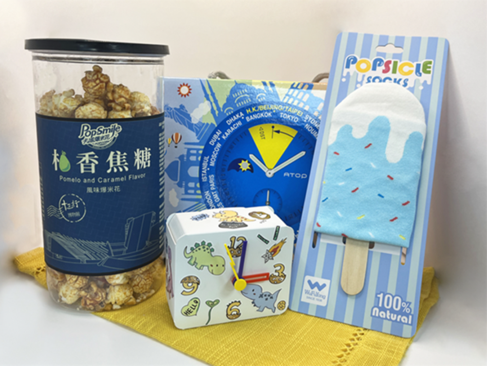 新北觀光工廠超值主題禮包8/29限量開賣 2 《圖說》適合親子家庭的「童趣探險包」,內含有卡滋爆米花觀光工廠樂園的柚香焦糖爆米花、王鼎時間科藝體驗館的時鐘DIY材料包及吳福洋襪子故事館的冰棒造型短襪。〈經發局提供〉