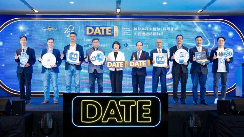 ▲貴賓手持DATE與數位經濟象徵之手舉牌大合影，左至右依序為：外貿協會數位商務處處長黃漢唐、CreatorDB產品管理與AI應用資深總監Dominic Cope、Taiwan Global Angels創辦人詹益鑑、總體經濟學家吳嘉隆、經濟部國際貿易署黃瀞萱主任秘書、外貿協會王熙蒙秘書長、聚界潔能股份有限公司臺灣董事長谷月涵、玉山國際加速器(Mosaic Venture Lab)總經理Volker Heistermann、意藍資訊股份有限公司創辦人暨總經理楊立偉、SUPER 8 Studio雲發互動科技創辦人暨執行長陳子龍。