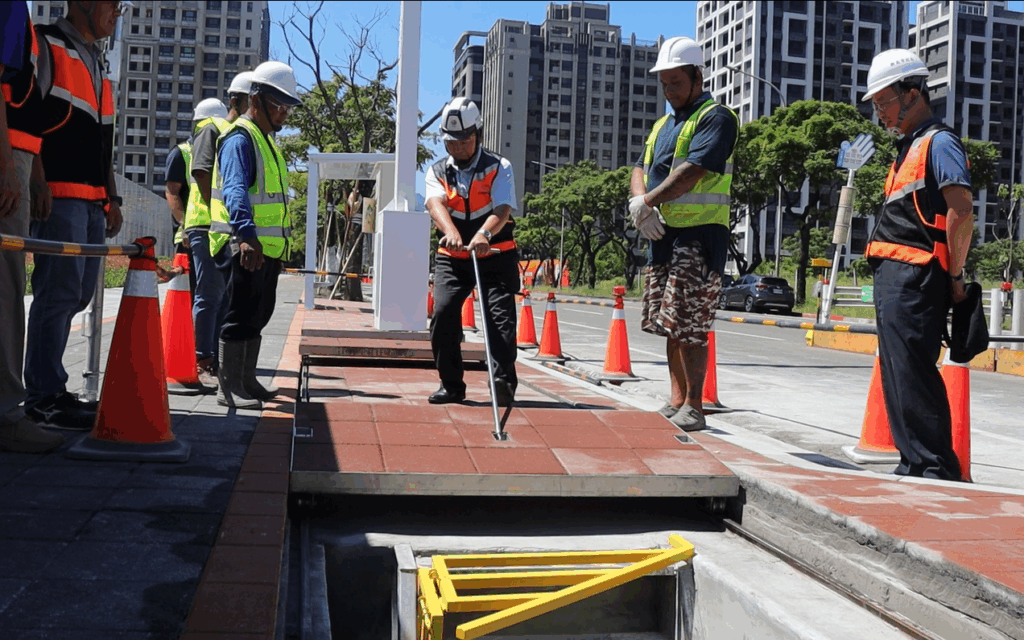 新北創新工法打造優質示範街廓 縮小淡海共管通風口 人行空間更順暢 3 %E5%B7%A5%E5%8B%99%E5%B1%80%E9%95%B7%E9%A6%AE%E5%85%86%E9%BA%9F%EF%BC%88%E4%B8%AD%EF%BC%89%E8%A6%AA%E8%87%AA%E6%93%8D%E4%BD%9C%E3%80%8C%E6%BB%91%E8%BB%8C%E5%BC%8F%E5%87%BA%E5%85%A5%E6%90%AC%E9%81%8B%E5%8F%A3%E3%80%8D%EF%BC%8C%E5%89%B5%E6%96%B0%E6%8A%80%E8%A1%93%E8%BC%95%E4%BE%BF%E7%9C%81%E5%8A%9B%EF%BC%8C%E5%83%85%E9%9C%80%E5%96%AE%E4%BA%BA%E5%8D%B3%E5%8F%AF%E9%96%8B%E5%95%9F%EF%BC%8C%E4%B8%A6%E5%B0%87%E7%AB%8B%E9%AB%94%E9%80%9A%E9%A2%A8%E5%8F%A3%E7%B8%AE%E5%B0%8F%E8%87%B3%E8%88%87%E5%9C%B0%E9%9D%A2%E9%BD%8A%E5%B9%B3%EF%BC%8C%E6%9C%89%E6%95%88%E9%87%8B%E6%94%BE%E4%BA%BA%E8%A1%8C%E7%A9%BA%E9%96%93%EF%BC%8C%E7%87%9F%E9%80%A0%E6%9B%B4%E8%88%92%E9%81%A9%E7%9A%84%E6%AD%A5%E8%A1%8C%E7%92%B0%E5%A2%83
