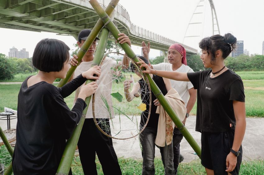 以藝術為橋濕地為伴 新北濕地藝術季10/4見 1 《圖說》策展人李蕢至協助創作營團隊學習如何在戶外設置藝術裝置。〈高灘處提供〉