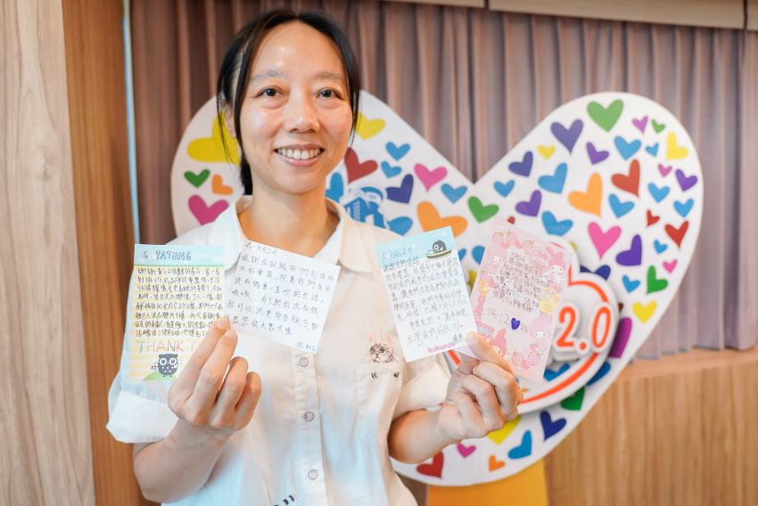 《圖說》國際奔享體驗教育發展協會督導謝惠雯帶著孩子們的手寫卡片出席捐贈儀式。〈社會局提供〉