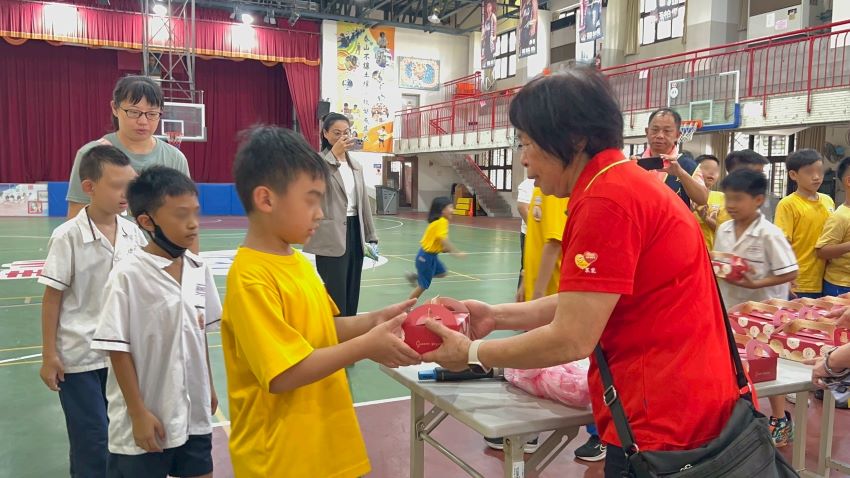 《圖說》眾能創新協會理事長黃芯愉贈送蛋黃酥給泰山國小弱勢學童  每人一盒6顆。〈社會局提供〉