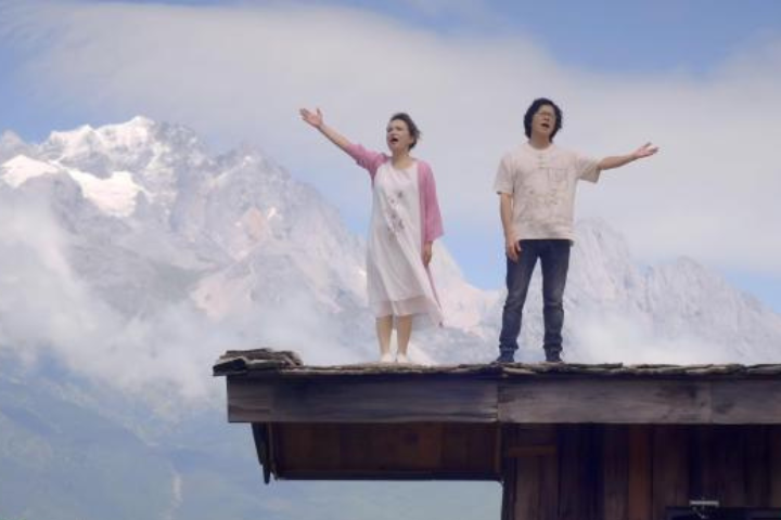 兩岸夫妻音樂人游純瑜（左）與謝學飛（右）在民歌大觀獻唱原創歌曲《兩岸一家親》。圖/翻攝自中新社視頻