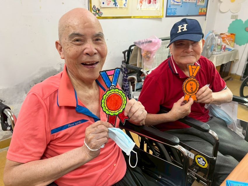 彩繪晚年 八德榮家〈心動時光〉畫出生命喜悅與感動 3 《圖說》八德榮家養護堂周伯伯(左1)完成手繪自製獎牌十分開心。〈八德榮家提供〉