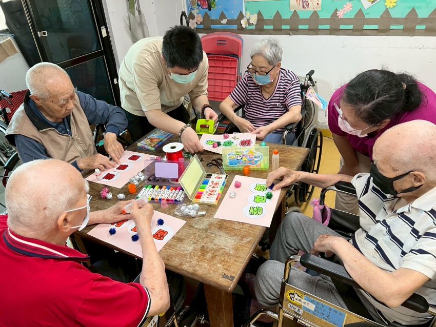彩繪晚年 八德榮家〈心動時光〉畫出生命喜悅與感動 4 《圖說》中山醫學大學社工實習生(後排左2)用心帶領住民長輩藝術創作。〈八德榮家提供〉