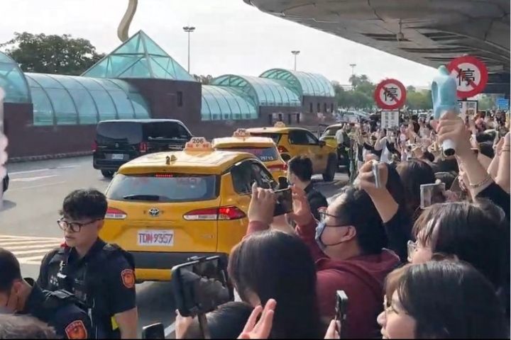 韓團TWICE將在高雄開唱，21日下午成員抵台，數百名粉絲擠滿高雄機場入境大廳和戶外連通道。（讀者提供）圖/中央社
