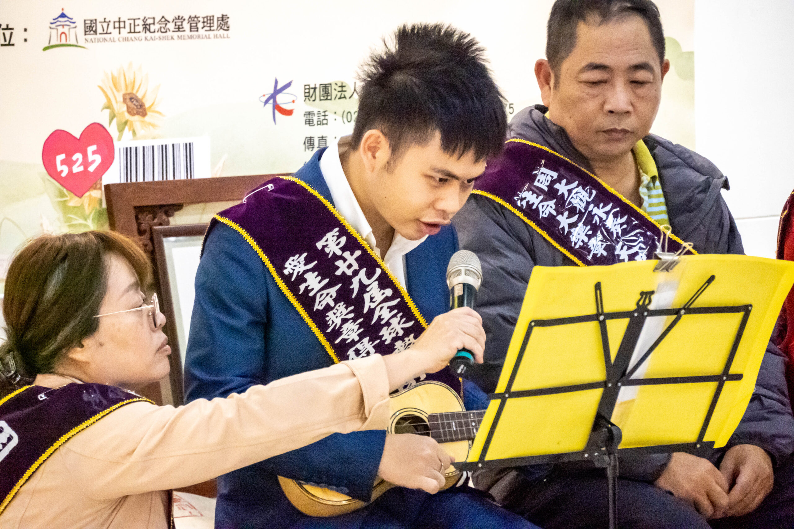 自閉多障畫家黃清棣在記者會上以烏克麗麗彈唱一曲《知足》。圖/記者黃楚甯攝