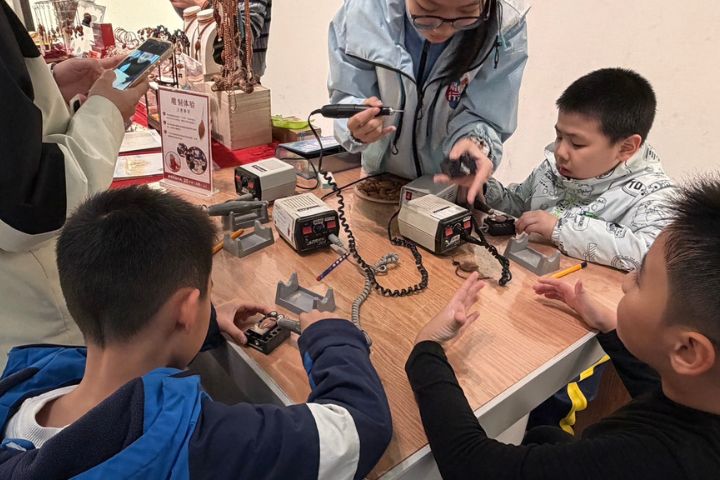 嶺南千年生活美學 廣州白鵝潭大灣區藝術中心匯聚廣東非遺 5 參觀的小朋友們親手體會傳統技藝。圖/記者陳素貞攝