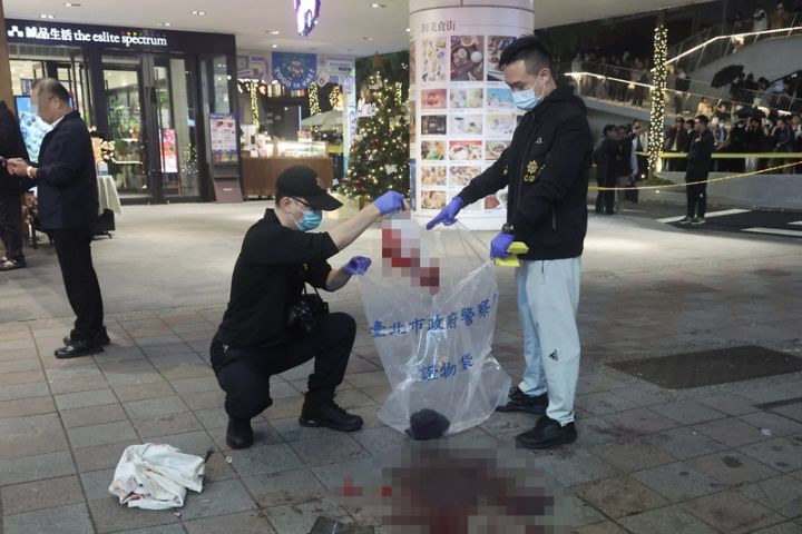 台北捷運中山站商圈19日晚間發生隨機傷人案，犯嫌與稍早在台北車站扔擲煙霧彈者為同一人。誠品南西店外地上血跡斑斑，警方鑑識小組將傷者遺落物品逐一蒐集採證。圖/中央社