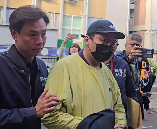 兩岸難聯手緝凶!太子集團陳志落網引渡大陸 台警嘆共打機制停擺難獲線索 20 圖為去年11月5日,在美方制裁柬埔寨太子集團犯罪組織後,檢調發動偵蒐行動,調查局幹員移送第二波在台重要幹部王昱棠(黃衣)至台北地檢署複訊。圖/中央社