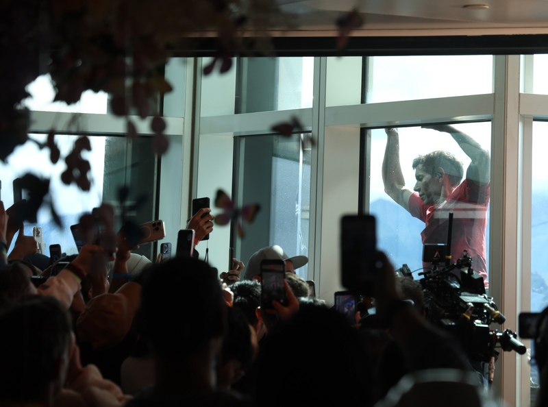 霍諾德挑戰徒手攀爬台北101，許多民眾在89樓觀景台為他加油打氣，拿起手機拍攝紀錄。圖/中央社