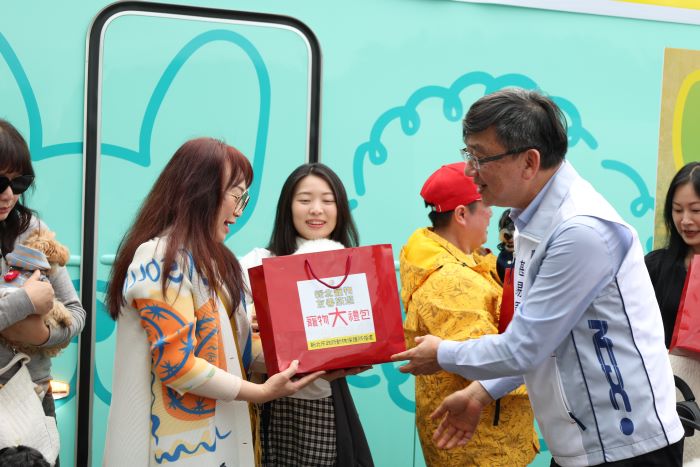 《圖說》農業局長諶錫輝致贈每位飼主寵物大禮包(寵物清潔濕紙巾、拾便袋、外出水壺及寵物零食。〈農業局提供〉