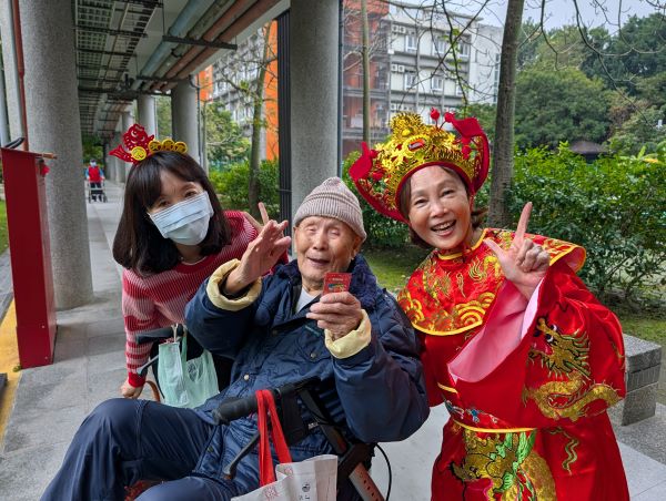 《圖說》陳桂美主任化身喜氣洋洋的財神爺，向長輩逐一致意拜年。〈板橋榮家提供〉