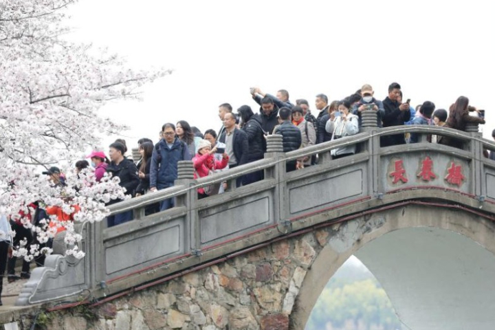 遊客在景區的長春橋上拍照遊玩。圖/取自新華社