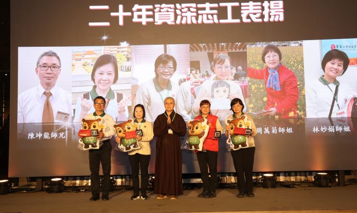 用生命寫希望照亮人生 普仁獎頒60小太陽 24 《圖說》靈鷲山法用法師贈送專屬的「五德公仔抱枕」給資深志工。(靈鷲山佛教教團提供)