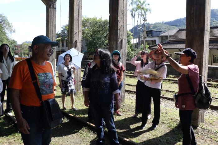 《圖說》礦工的女兒楊桂馨（右1）為遊客解說卸煤櫃的運作。〈社會局提供〉