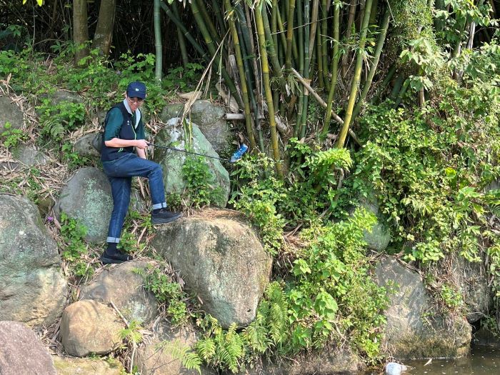 倡議自然共好 台電北市區處攜手家屬守護山林 6 《圖說》台電同仁不畏艱難深入石縫撿拾廢棄物 還給山林純粹原貌。〈台電台北市區處提供〉