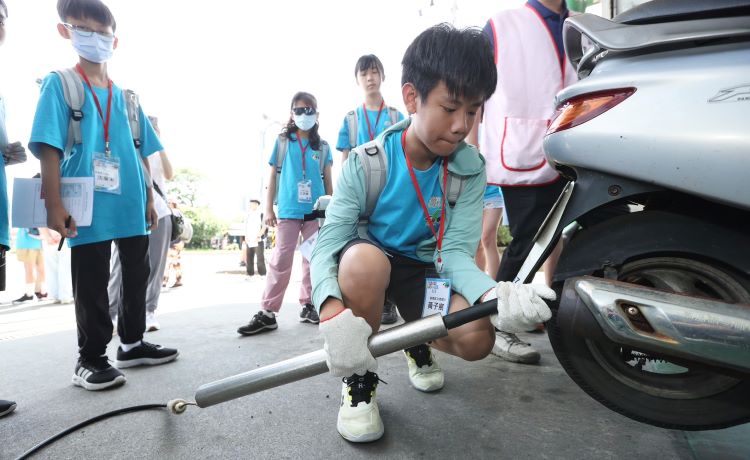 《圖說》環保小局長體驗機車排氣檢測。〈環保局提供〉
