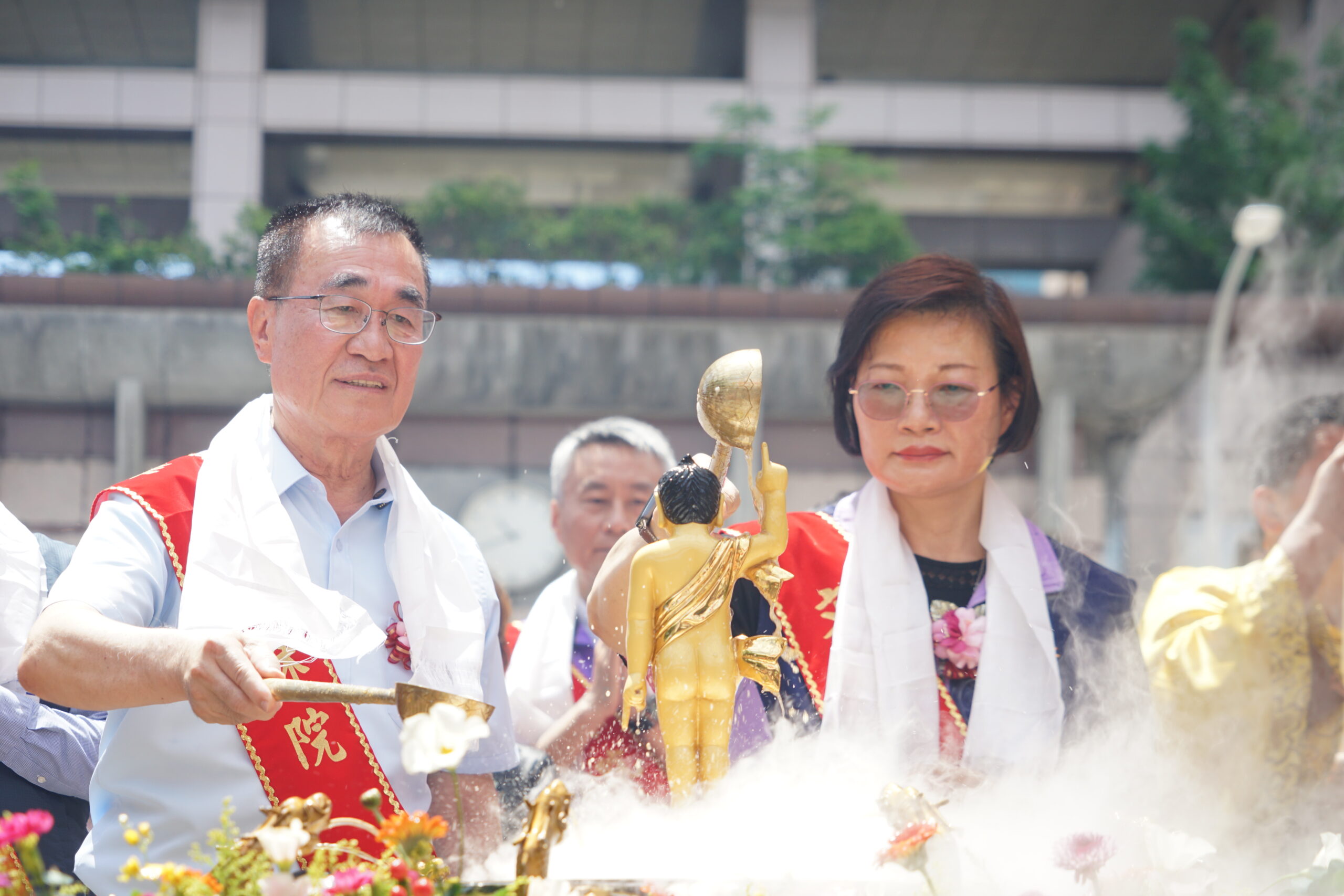 《圖說》世界佛教正心會於板橋站前廣場舉辦浴佛，李四川前副市長及新北市政府社會局李美珍局長浴佛。〈佛教正心會提供〉